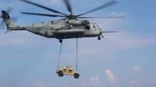 Heavy CH-53E Super Stallion Hoists a Humvee Off th...